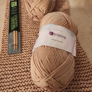 Beige knitting yarn with knitting needles